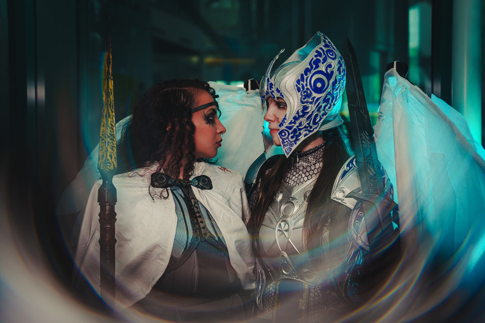 Two cosplayers in detailed fantasy costumes and armor